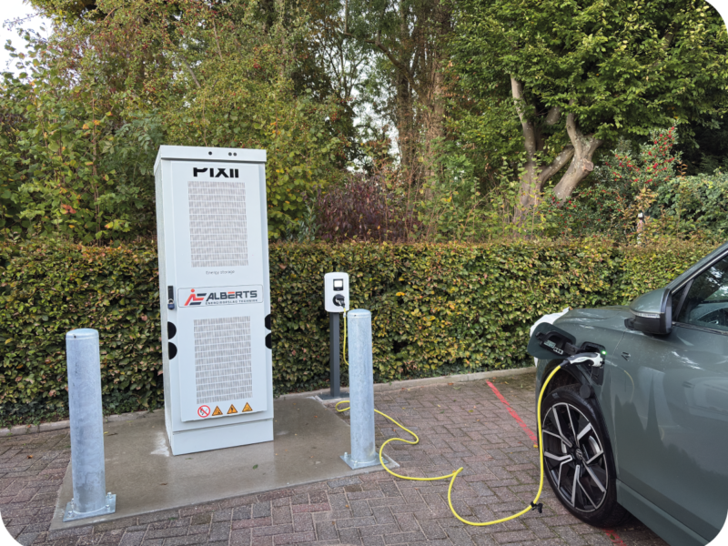 Pixii PowerShaper2 geplaatst in een groene omgeving inclusief een laadpaal.